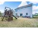 Expansive backyard featuring an outdoor kitchen, patio, and a wooden playset at 16803 Cozy Cove Rd, Charlotte, NC 28278