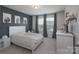 Comfortable bedroom featuring a queen bed, neutral carpet, and an accent wall at 16803 Cozy Cove Rd, Charlotte, NC 28278