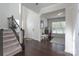 Inviting foyer with hardwood floors, staircase with railing, and views into adjoining living spaces at 16803 Cozy Cove Rd, Charlotte, NC 28278