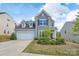 Charming two-story home featuring a manicured lawn, a two-car garage, and appealing architectural details at 16803 Cozy Cove Rd, Charlotte, NC 28278