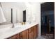 Bathroom vanity featuring dual sinks, wood cabinetry, and neutral countertop at 17309 Knoxwood Dr, Huntersville, NC 28078