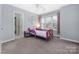 Bright bedroom features a purple metal frame bed, gray walls, and large window at 17309 Knoxwood Dr, Huntersville, NC 28078
