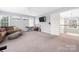 Spacious bonus room with gray walls, carpet, television, sofa, and staircase entrance at 17309 Knoxwood Dr, Huntersville, NC 28078