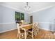 Sunlit dining area with hardwood floors, table for six, and crown molding at 17309 Knoxwood Dr, Huntersville, NC 28078