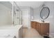 Bathroom with a tiled floor, wood vanity, a framed mirror, and glass enclosed shower at 17309 Knoxwood Dr, Huntersville, NC 28078