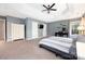 Spacious main bedroom featuring a ceiling fan, tray ceiling, and a dedicated desk area at 17309 Knoxwood Dr, Huntersville, NC 28078