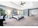 Bright main bedroom with a ceiling fan, large windows, and ensuite bathroom access at 17309 Knoxwood Dr, Huntersville, NC 28078