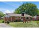 Side view of a quaint brick home with a chimney and mature trees providing shade at 175 Neita Dr, Salisbury, NC 28147