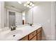 Well-lit bathroom featuring a double sink vanity, large mirror, and a shower with tub at 2004 Ptarmigan Ct, Waxhaw, NC 28173