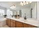 Bathroom with double sink vanity with wood cabinets, large mirror, and separate soaking tub at 2004 Ptarmigan Ct, Waxhaw, NC 28173