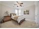 Cozy bedroom with a wood-frame bed, dresser, soft lighting, and a large window for natural light at 2004 Ptarmigan Ct, Waxhaw, NC 28173