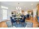 Elegant dining room with a round glass table, blue chairs, and a stylish chandelier at 2004 Ptarmigan Ct, Waxhaw, NC 28173