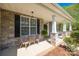 Cozy front porch featuring stone accents, a seating area, and a welcoming entrance adorned with lush greenery at 2004 Ptarmigan Ct, Waxhaw, NC 28173