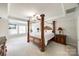 Spacious main bedroom with a four-poster bed, tray ceiling, and large windows with natural light at 2004 Ptarmigan Ct, Waxhaw, NC 28173