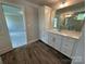 Modern bathroom featuring a white vanity with cabinets, a large mirror, and wood look flooring at 2017 Embassy Ct # 51, Charlotte, NC 28213