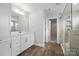 Modern bathroom featuring marble tile shower with glass door, wood-look flooring, and white vanity with ample storage at 2017 Embassy Ct # 51, Charlotte, NC 28213