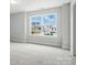 Bedroom with neighborhood view through large window providing ample natural light at 2017 Embassy Ct # 51, Charlotte, NC 28213