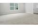 This bedroom features a large window and carpet flooring with a doorway leading to the laundry area at 2017 Embassy Ct # 51, Charlotte, NC 28213
