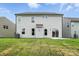 Exterior view of the home's rear featuring a sliding glass door and well-maintained lawn at 2017 Embassy Ct # 51, Charlotte, NC 28213