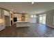 Open-concept kitchen with island, white cabinets, stainless appliances, and sliding door access at 2017 Embassy Ct # 51, Charlotte, NC 28213