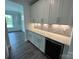 Butler's pantry with white cabinets, a marble backsplash, counter space, and a wine refrigerator at 2017 Embassy Ct # 51, Charlotte, NC 28213