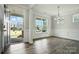 Bright, open-concept living room boasts hardwood floors, modern chandelier and ample natural light at 2017 Embassy Ct # 51, Charlotte, NC 28213