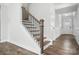 This staircase showcases dark wood treads, white risers, and wrought iron balusters with a wood handrail at 2017 Embassy Ct # 51, Charlotte, NC 28213