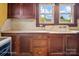 Farmhouse kitchen with abundant wood cabinets, vintage-style sink, and natural light through windows at 203 Ackert Ave, Salisbury, NC 28144