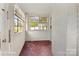 Bright sunroom features white brick walls, multiple windows with blinds, and unique mosaic tile flooring at 203 Ackert Ave, Salisbury, NC 28144
