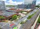 An aerial view of a vibrant district with commercial buildings, streets, and train tracks, capturing urban energy at 2094 Euclid Ave, Charlotte, NC 28203