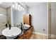 This bathroom has dual vessel sinks, hardwood floors, modern cabinets, and a glass-enclosed shower at 2094 Euclid Ave, Charlotte, NC 28203