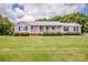 Well maintained front yard of ranch home with mature trees and an inviting front porch at 2811 Saint James Church Rd, Denver, NC 28037