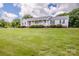 Beautifully landscaped front yard with mature trees, green grass and a charming ranch style home at 2811 Saint James Church Rd, Denver, NC 28037