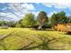A sprawling back yard offers ample space for recreation and features mature trees and lush green grass at 311 Cooks Lake Rd, Gastonia, NC 28056