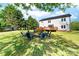 Spacious backyard featuring a fire pit, deck, and lush green lawn, perfect for outdoor entertaining at 311 Cooks Lake Rd, Gastonia, NC 28056