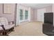 Cozy bedroom featuring plush carpeting, pastel pink walls, white trim, and a comfortable rocking chair at 311 Cooks Lake Rd, Gastonia, NC 28056