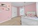 Childs bedroom featuring pink walls, two windows, and a double door closet at 311 Cooks Lake Rd, Gastonia, NC 28056