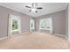 Spacious bedroom with neutral walls, plush carpet, three windows, and a ceiling fan at 311 Cooks Lake Rd, Gastonia, NC 28056