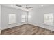 Minimalist bedroom with wood-look floors, three windows, and a neutral color palette at 4004 Crooked Spruce Ct, Matthews, NC 28105