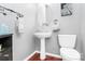 Stylish bathroom with a pedestal sink, oval mirror, and dark wood-look flooring at 4086 Buckingham Dr, Fort Mill, SC 29707
