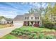 Inviting two-story home with manicured lawn and colorful landscaping around the front porch and a two-car garage at 4086 Buckingham Dr, Fort Mill, SC 29707