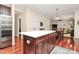 Kitchen island with white countertop, cherry cabinets, and an open view of living area at 4086 Buckingham Dr, Fort Mill, SC 29707