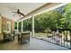 Covered porch offers outdoor seating, ceiling fan, and a tranquil backyard view with fireplace at 5001 Oxfordshire Rd, Waxhaw, NC 28173