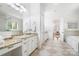 A bathroom with dual sinks, white cabinets, granite countertops, and tiled floors at 5001 Oxfordshire Rd, Waxhaw, NC 28173
