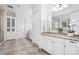 A bathroom with dual sinks, white cabinets, granite countertops, and tiled floors at 5001 Oxfordshire Rd, Waxhaw, NC 28173