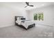 Bedroom with carpet flooring, a ceiling fan, a large window, and a gray bed with white bedding at 5001 Oxfordshire Rd, Waxhaw, NC 28173