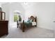 Bedroom featuring a decorative bed frame, an arched window, carpet flooring, and a dark wood dresser at 5001 Oxfordshire Rd, Waxhaw, NC 28173