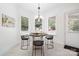 A breakfast nook with a round table, three chairs, and windows overlooking the yard at 5001 Oxfordshire Rd, Waxhaw, NC 28173