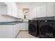 A laundry room with a washer, a dryer, white cabinets, and green countertops at 5001 Oxfordshire Rd, Waxhaw, NC 28173