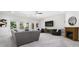 Spacious living room featuring a fireplace, several windows, gray sofas, and dark wood accent furniture at 5001 Oxfordshire Rd, Waxhaw, NC 28173